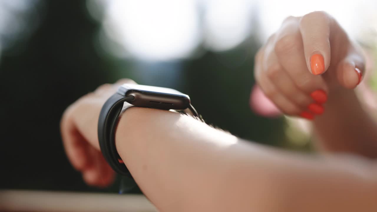 女人使用她的智能手表触摸屏可穿戴技术设备。年轻女子正在试用新款智能手表。聪明的手表。女性腕上的智能手表视频素材
