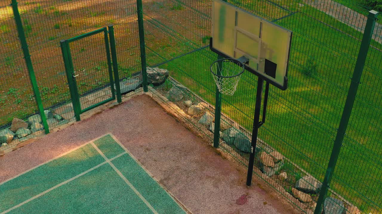 俯视图篮球运动员接近，得分篮框在户外篮球场上锻炼在阳光下视频下载