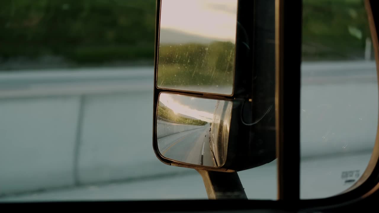 在白天的阳光下，卡车司机在公路上驶向目的地货物。慢动作特写镜头。视频素材