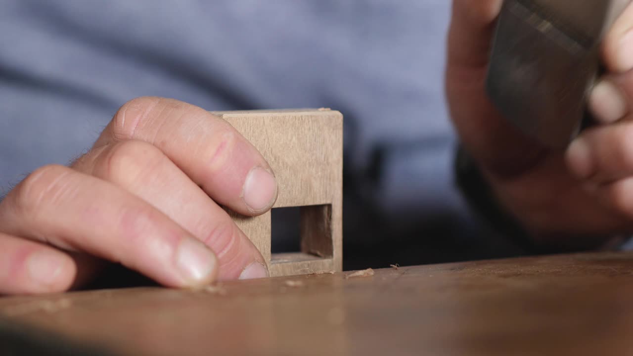 木匠用小刨子刨去一块木头的倒角。木工刨平。手木工工具视频下载