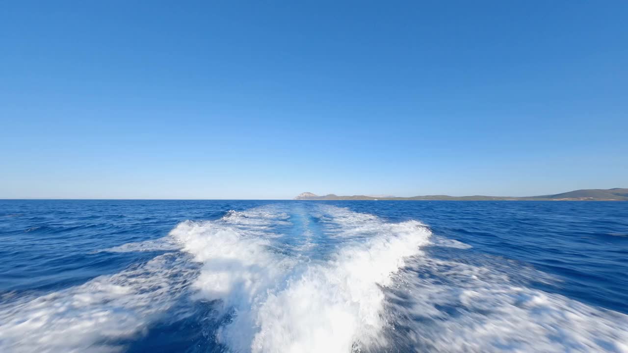 一艘游船在蓝色的水面上高速航行形成的水迹，令人惊叹。意大利撒丁岛翡翠海岸。视频素材