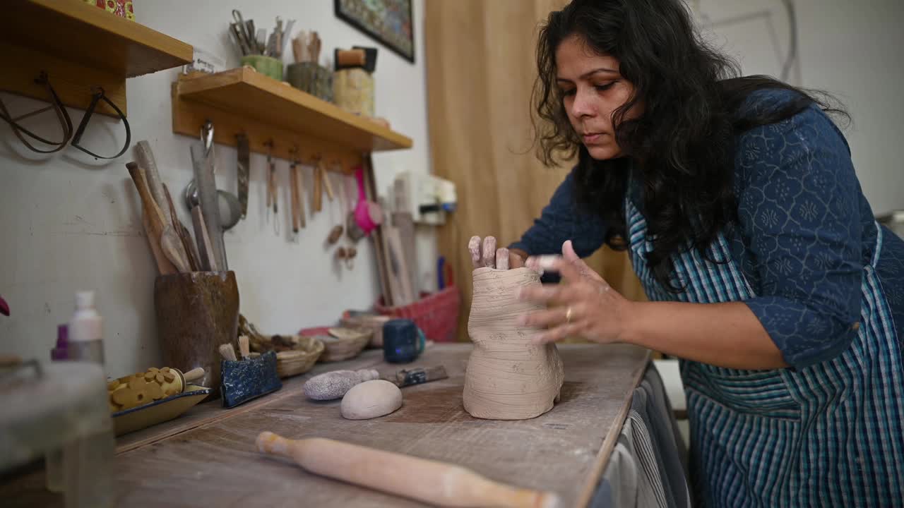 女陶瓷艺术家用她的手给她的陶瓷花瓶造型视频素材