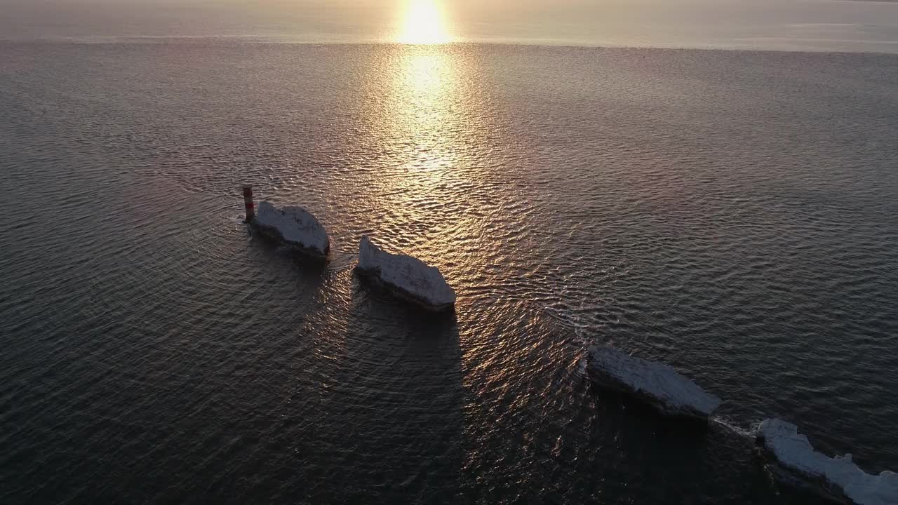 英国怀特岛，日落时从尼德斯岛向后移动的航拍视频下载