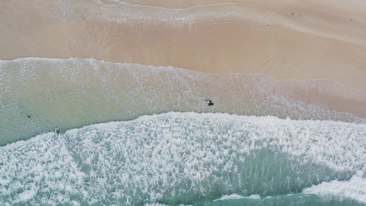 英国康沃尔郡纽基的菲斯特拉海滩，无人机直接在海浪上方拍摄视频下载
