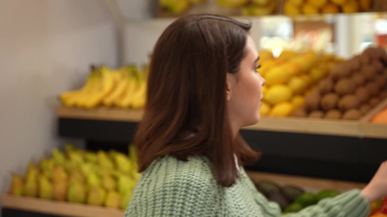在杂货店挑选新鲜水果的女人视频素材