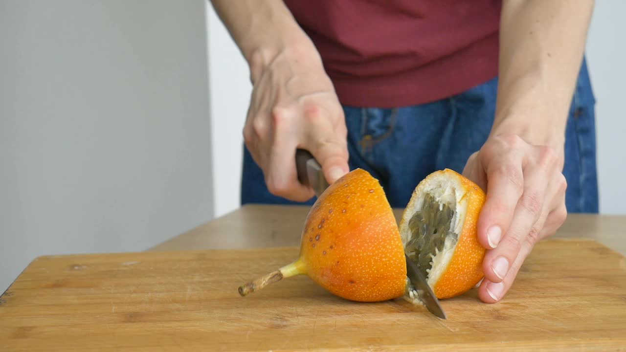 新鲜的有机熟果或黄色的百香果，在木板上切成两半。异域水果，健康饮食理念视频素材