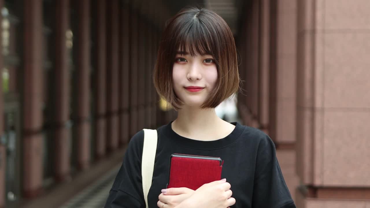 年轻的亚洲女人拿着一个数字平板电脑视频素材