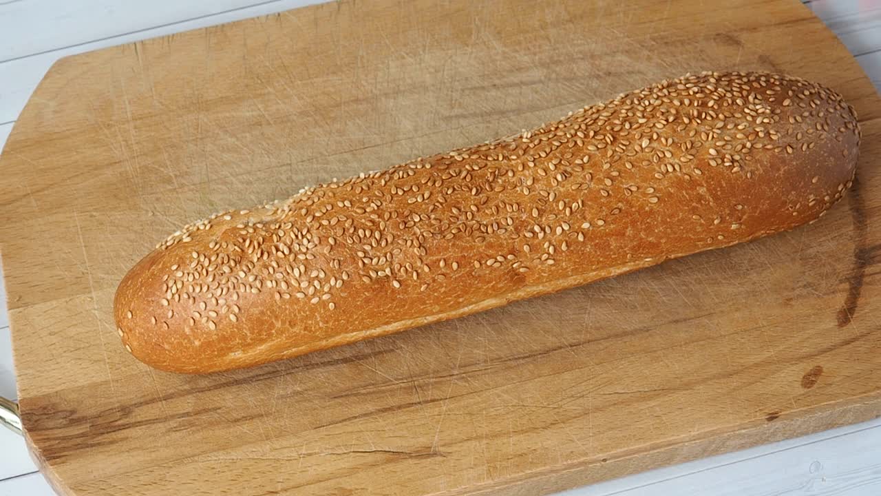 法式长棍面包是用小刀在木板上切成片的视频素材