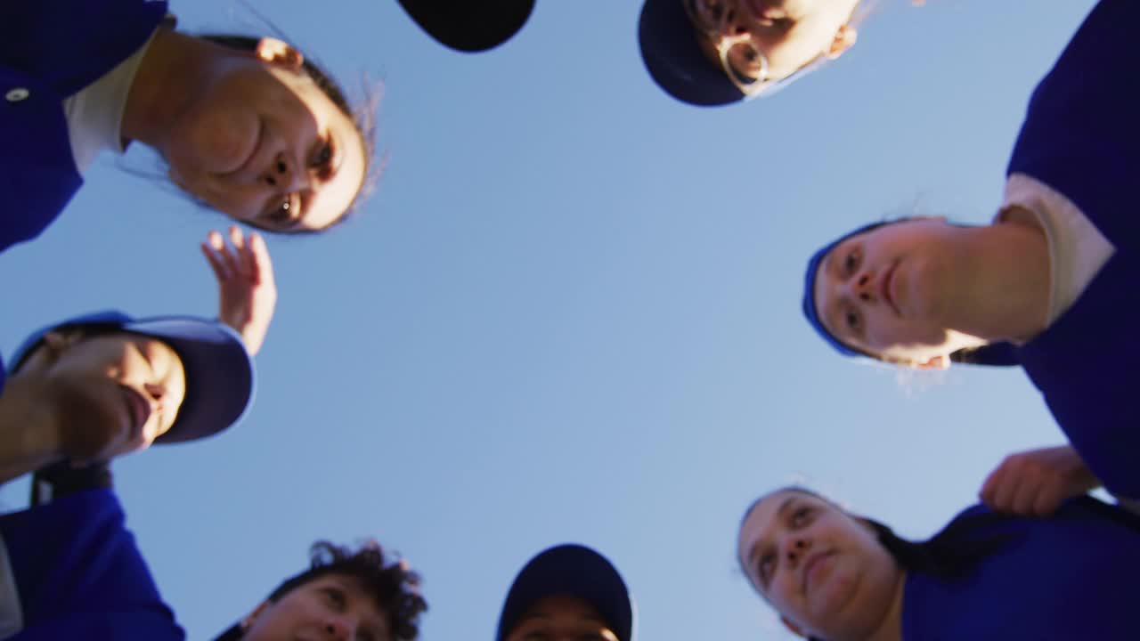 低角度观看不同群体的女棒球运动员在蓝天下手工堆叠视频下载