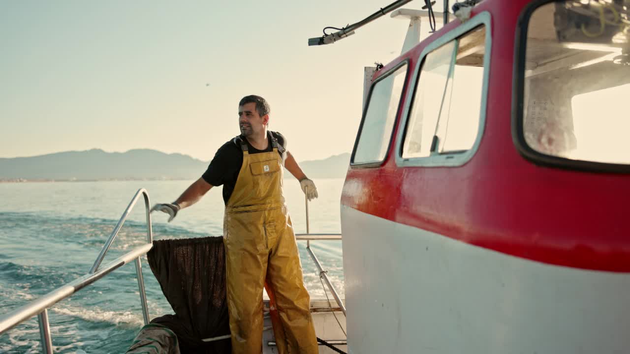 渔民在小型拖网渔船上驾驶的动作肖像视频下载