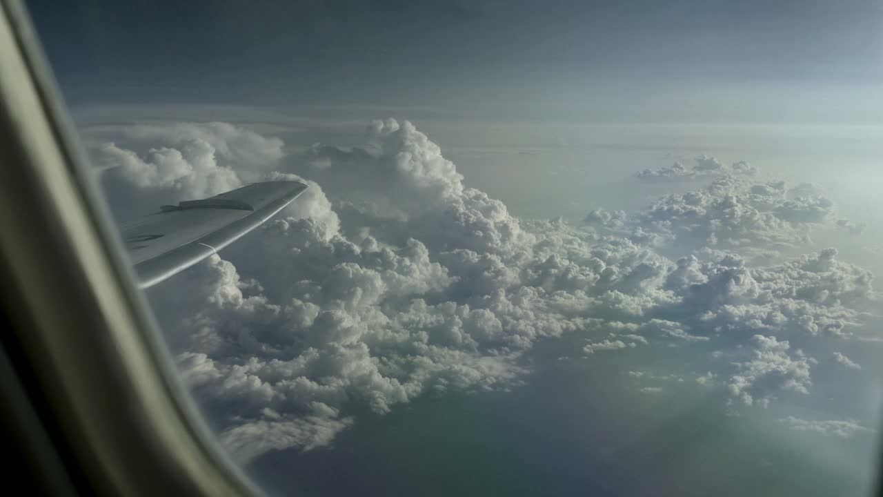 从云层上飞过山脉，透过飞机窗口观看视频素材