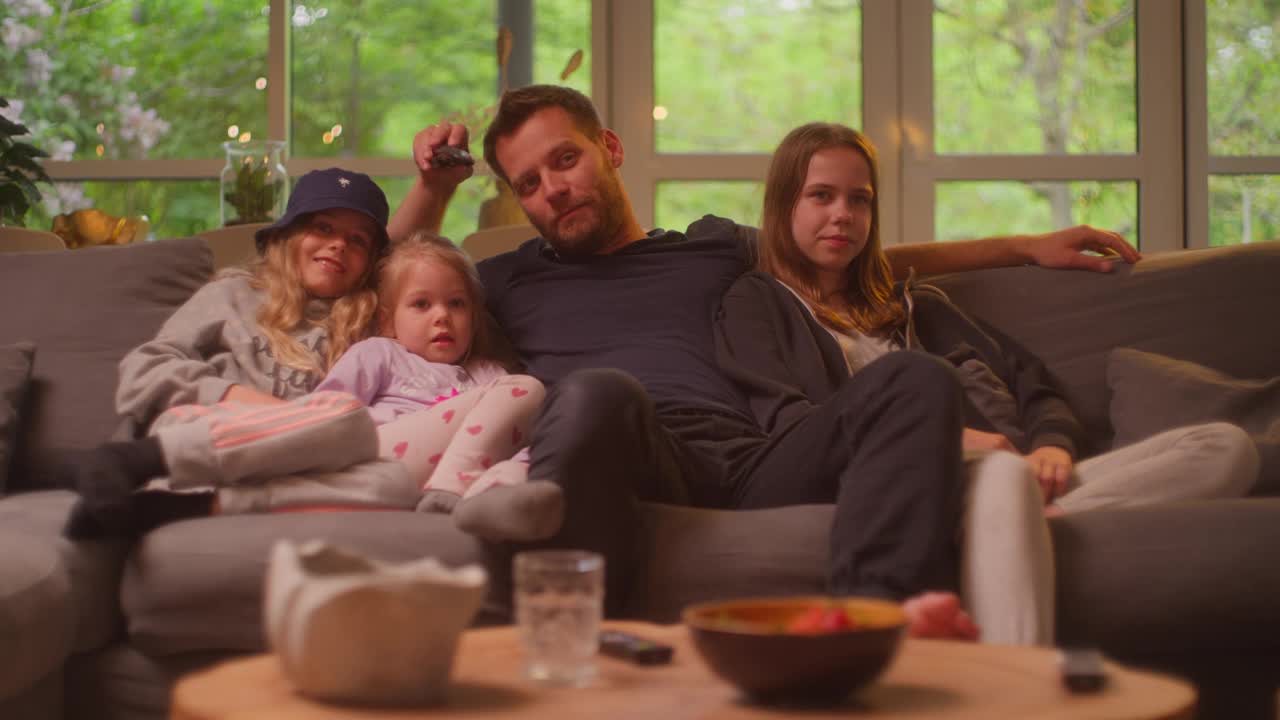 在家看电视。父亲和三个女儿在一起视频素材