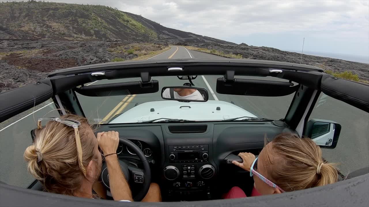 摄像机安装在车顶上，敞篷车在夏威夷大岛的火山景观上行驶。汽车视角视频素材