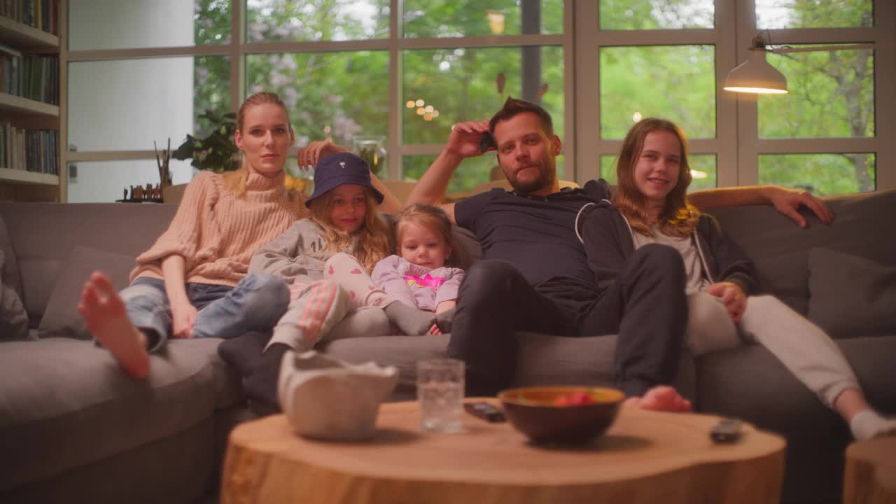 在家看电视。一家人和三个女儿在一起。吃零食视频素材