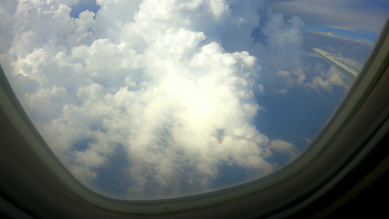 在美丽的白云中飞行-透过飞机窗口观看视频素材
