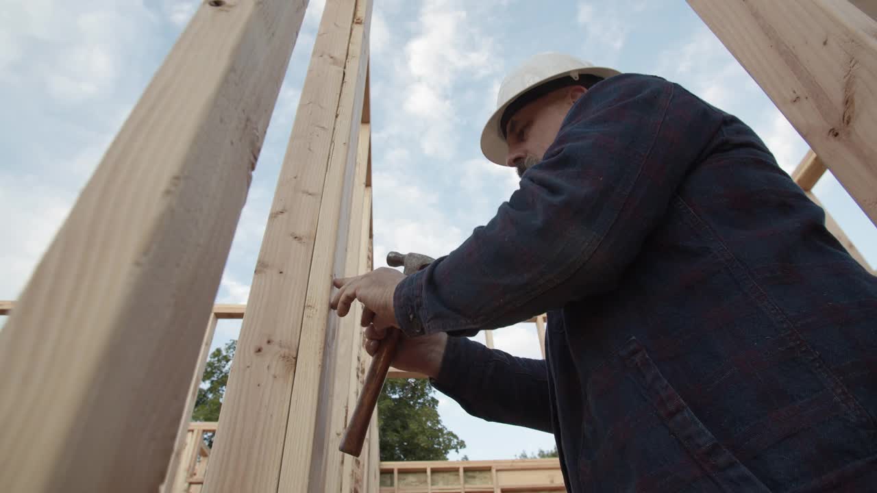 CU建筑工人戴着安全帽建造房子视频下载