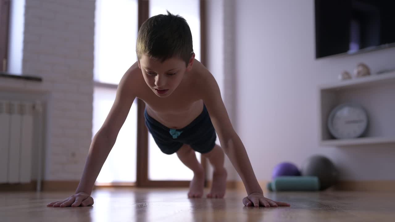 积极健康的幼儿在室内训练中做俯卧撑肌肉运动休闲活动方式视频下载