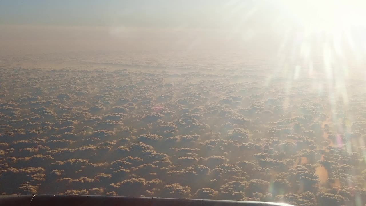 全景鸟瞰图从飞机飞行在白色蓬松的云在日出，日落视频下载