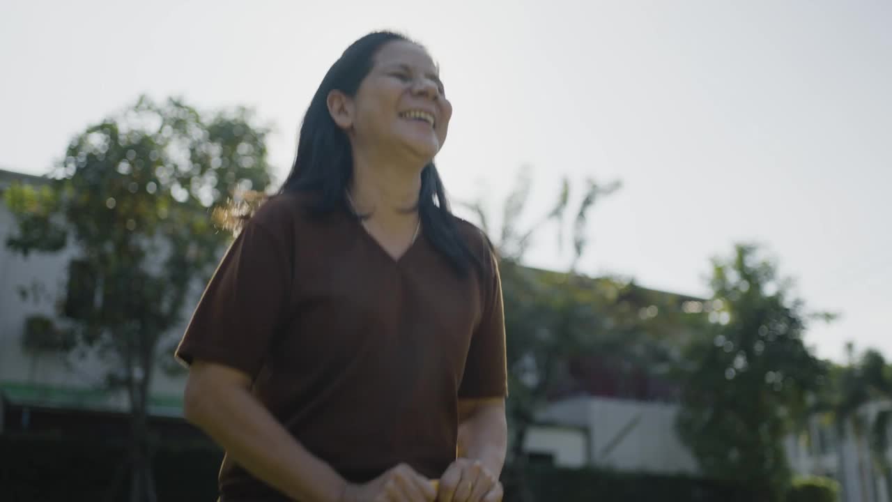 在阳光明媚的日子玩跷跷板的亚洲快乐的女人视频素材