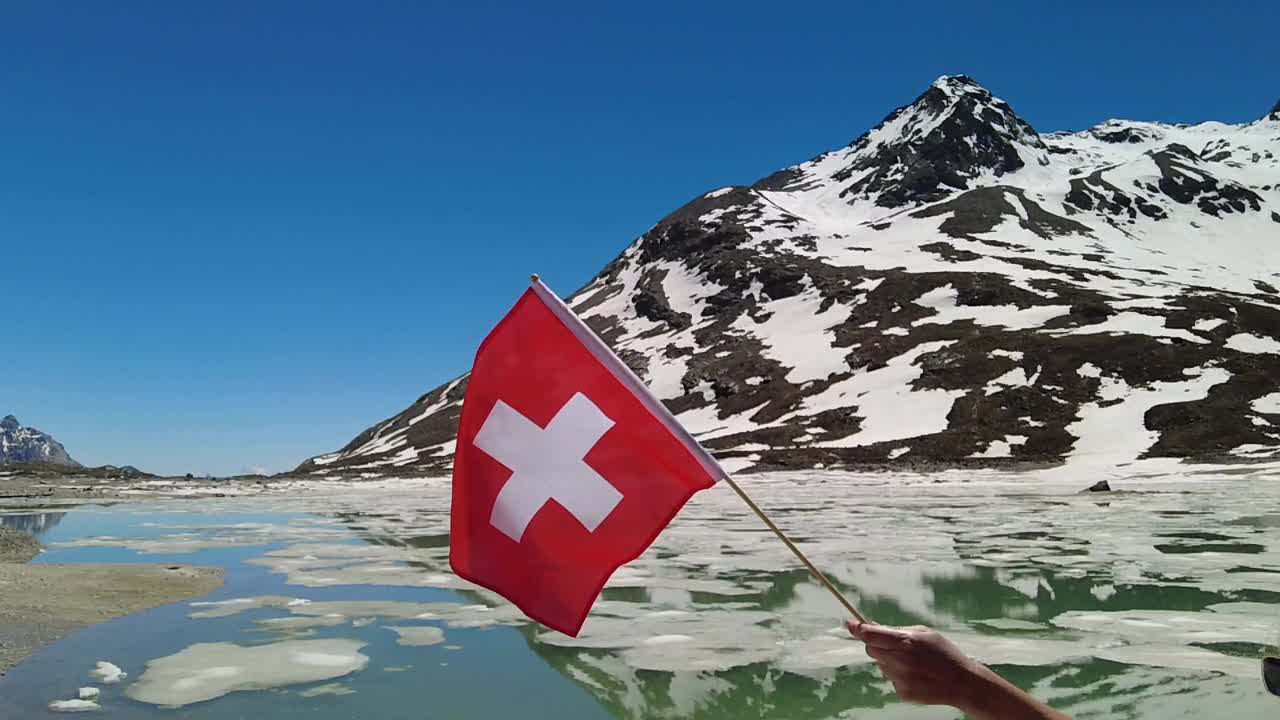 白湖上慢镜头中的瑞士国旗视频下载