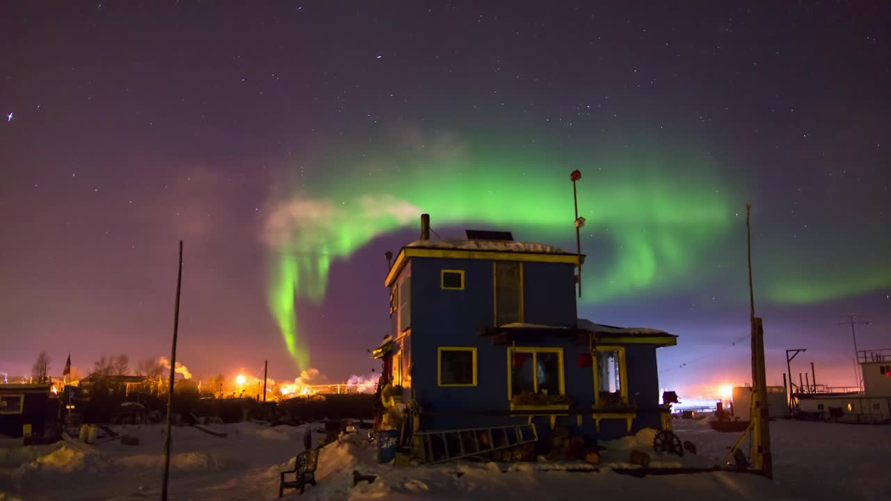 在加拿大温哥华的冬季夜晚，蓝色房子在极光下释放烟雾视频素材