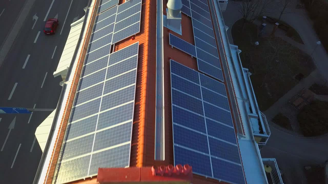 住宅建筑屋顶顶部的太阳能电池板，用于生产绿色生态电力。视频素材