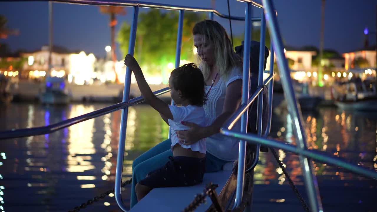 母亲和儿子晚上在游艇上享受视频素材