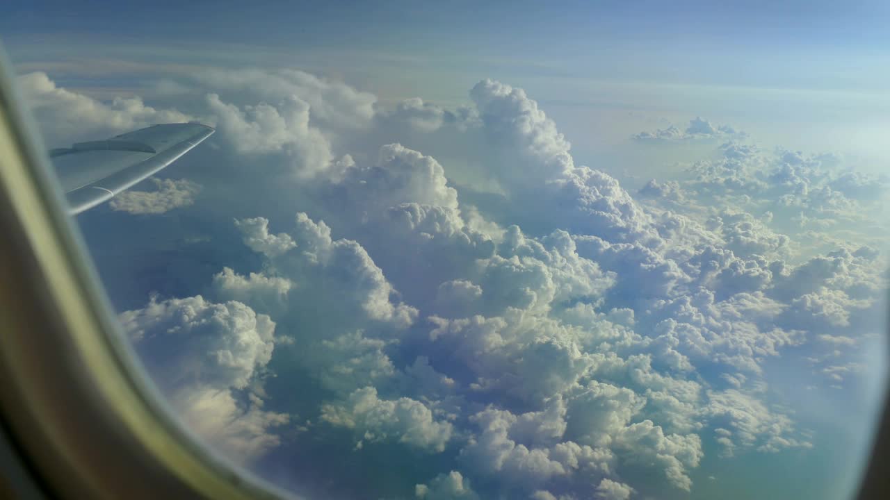 从飞机窗口看到地面上的云层视频素材