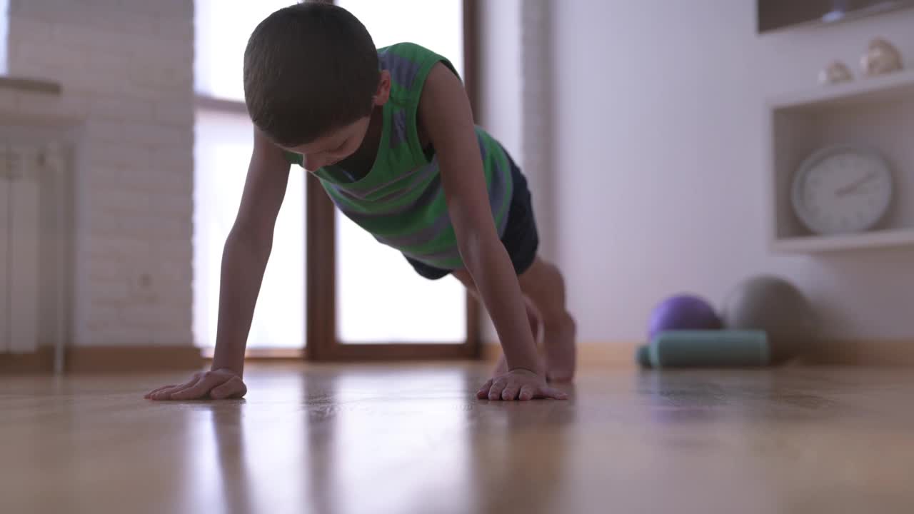 积极健康的幼儿在室内训练中从地板上做俯卧撑锻炼肌肉运动休闲活动的生活方式视频下载
