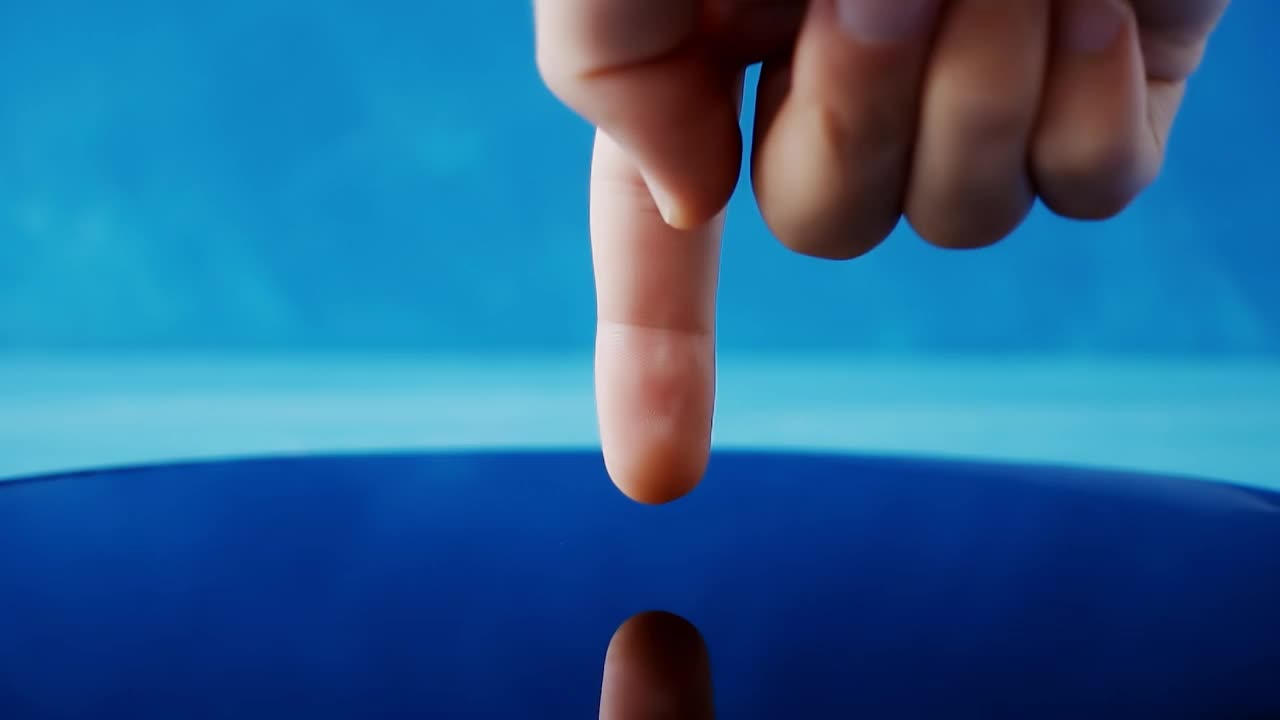 一个人的手用手指触摸水面的慢动作视频。视频下载