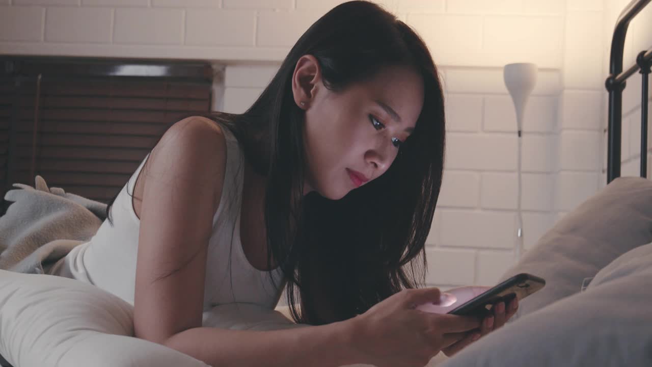 女人晚上用手机和男朋友聊天。社交媒体上的在线约会。与人沟通。视频素材