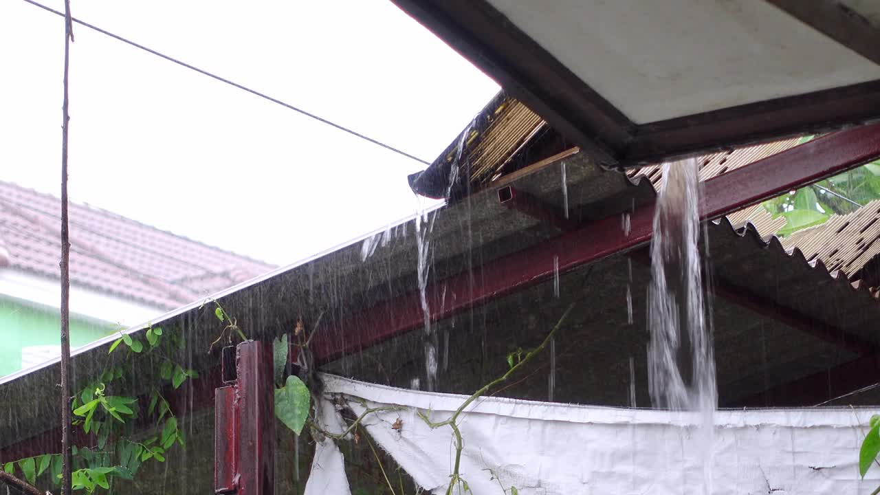 大雨从村子房子前面的排水沟中流过视频素材