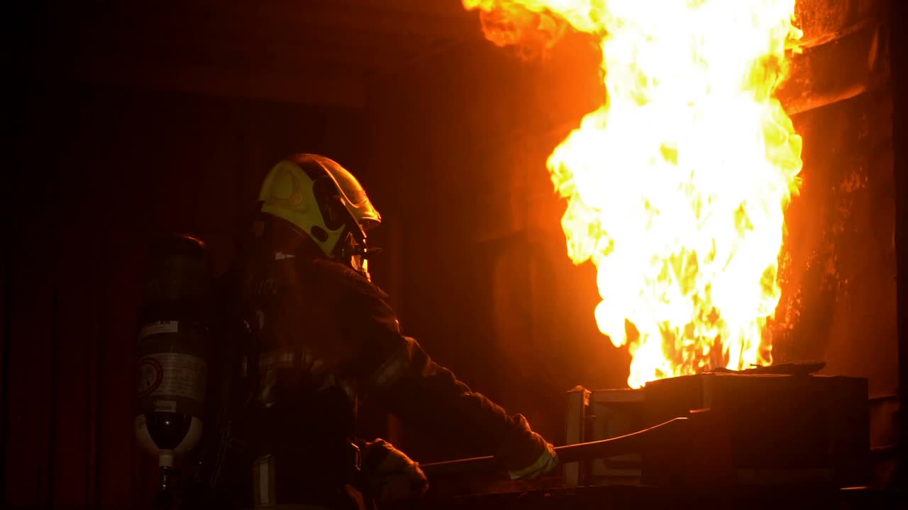 消防队员用斧头试图在燃烧的建筑物中灭火视频素材