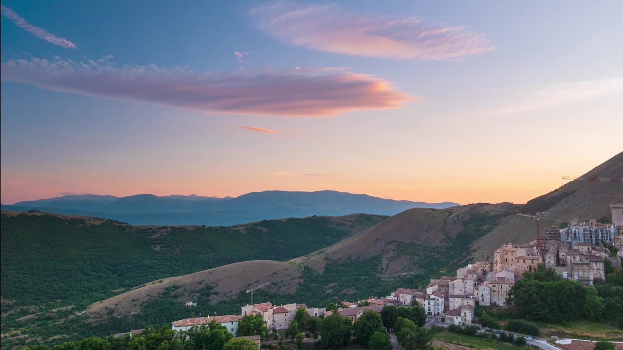 时间流逝:意大利阿布鲁佐圣斯特凡诺迪塞塞尼奥山顶上中世纪村庄的日落。浪漫的天空和云朵之上独特的山丘和山脉景观，情感的感受概念，旅游目的地。视频素材