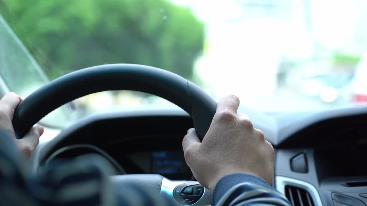 司机在方向盘后，一名男子保持他的手在方向盘上驾驶，从车内的视频视频素材