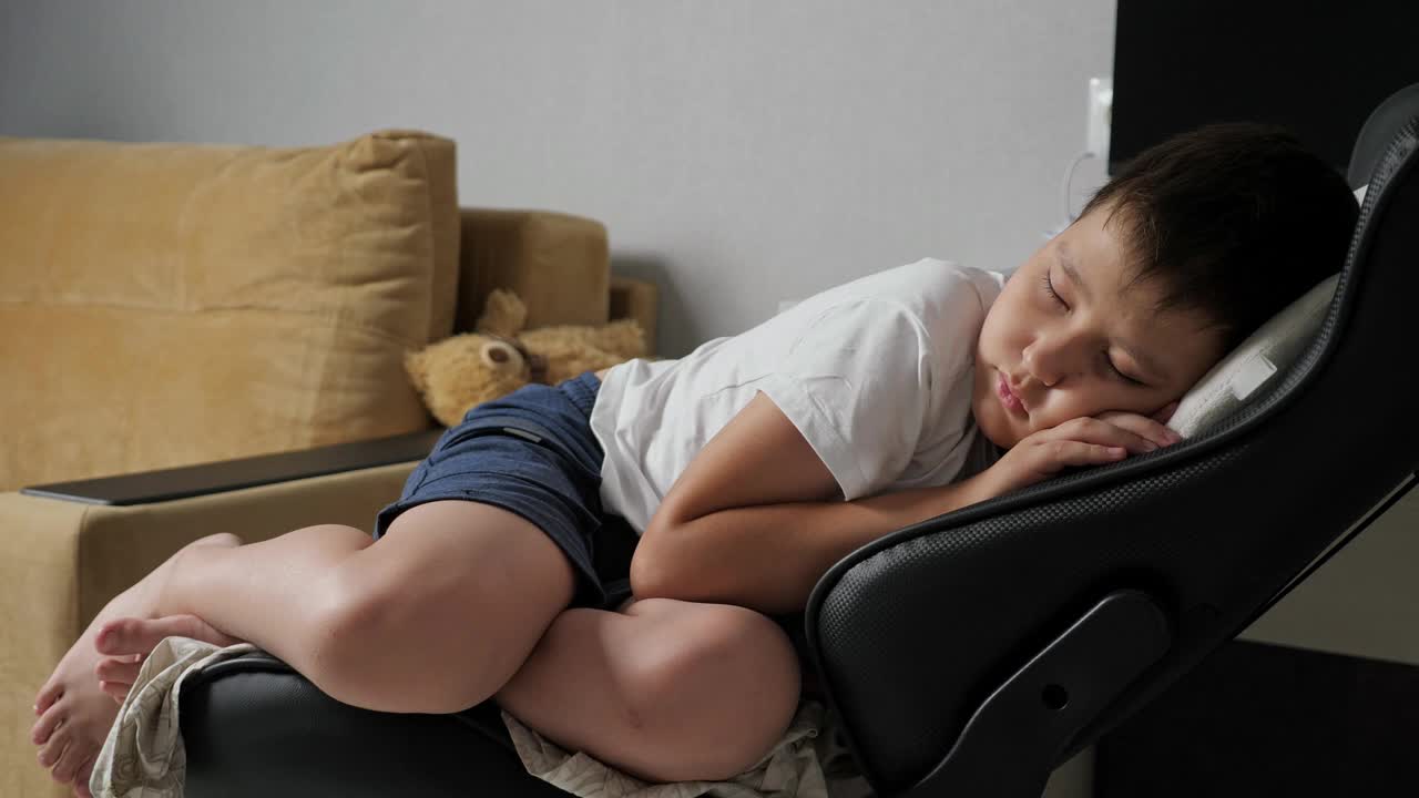 男孩在电脑椅上睡得很香视频素材