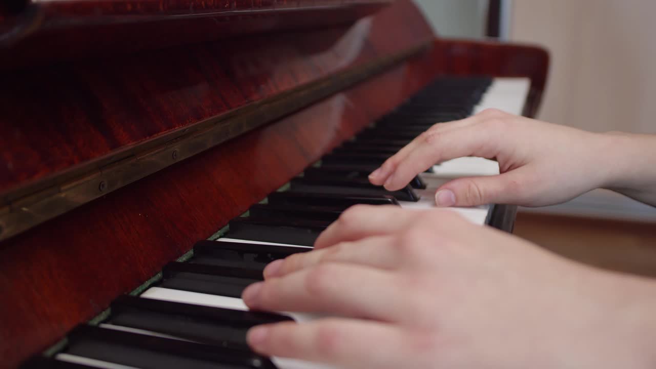 女性手弹钢琴，特写，侧视室内。演奏乐器和古典音乐的概念视频素材