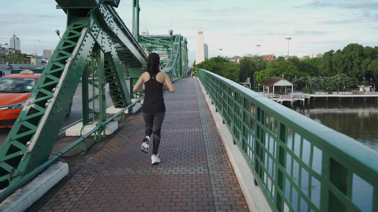 亚洲年轻女子在城市大桥上跑步视频下载