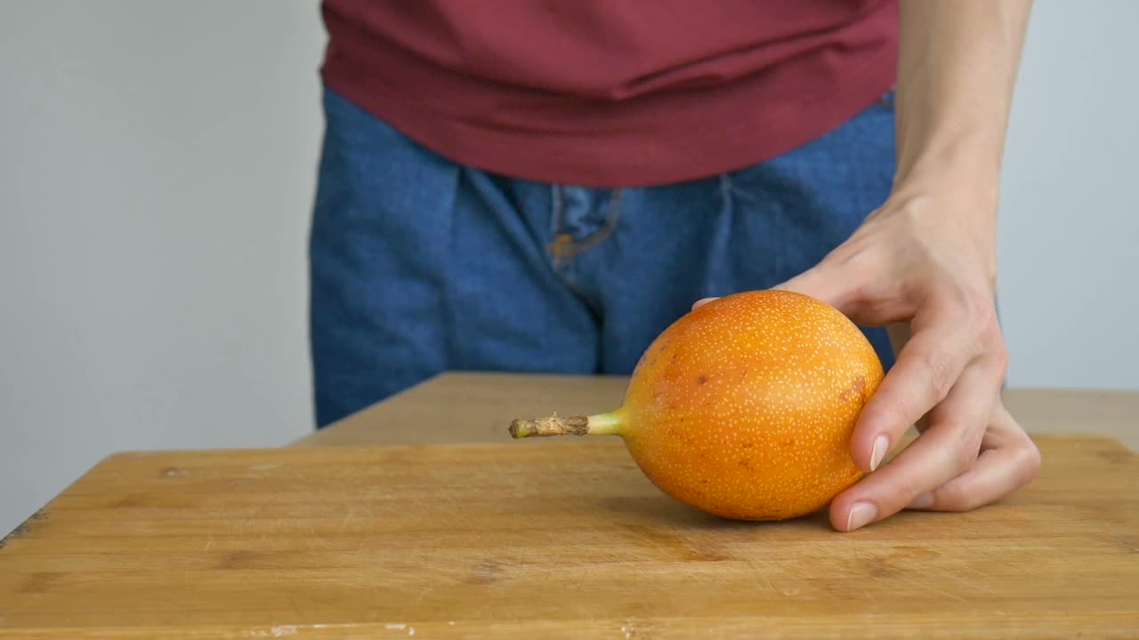 新鲜的有机成熟的格拉纳迪拉或黄色百香果切成两半放在木板上。异域水果，健康饮食理念视频素材