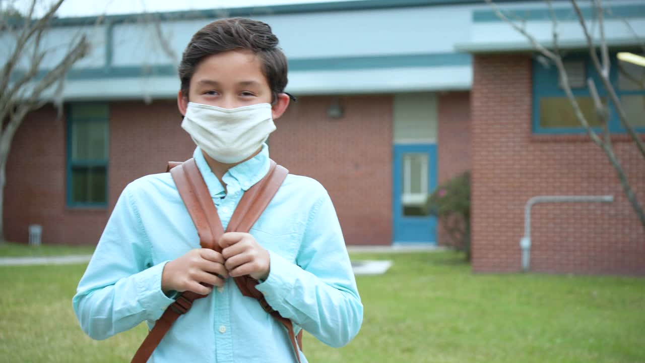 混血男孩，在covid-19期间戴着口罩回学校视频下载