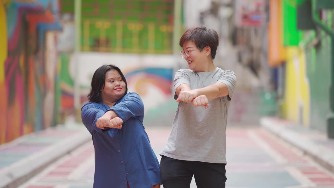 快乐的亚洲马来自闭症唐氏综合症女性与她的朋友在城市街道跳舞视频下载