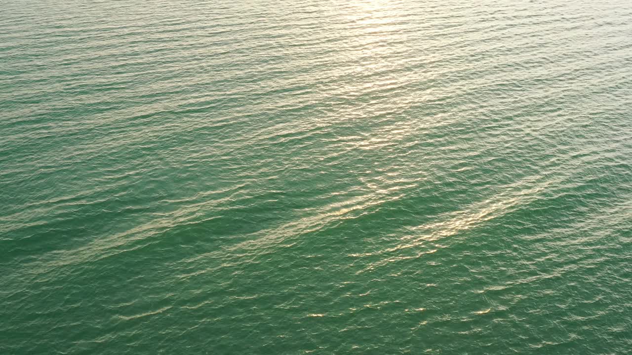 无人机在波纹的海水表面反射阳光的观点视频素材