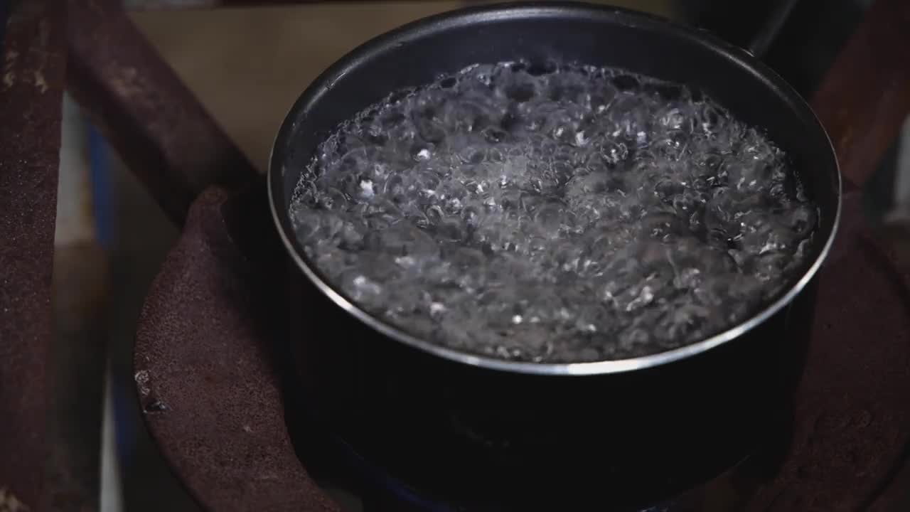 厨师把煮熟的米饭放进锅里的沸水里，把米饭放进炉子上的锅里视频素材