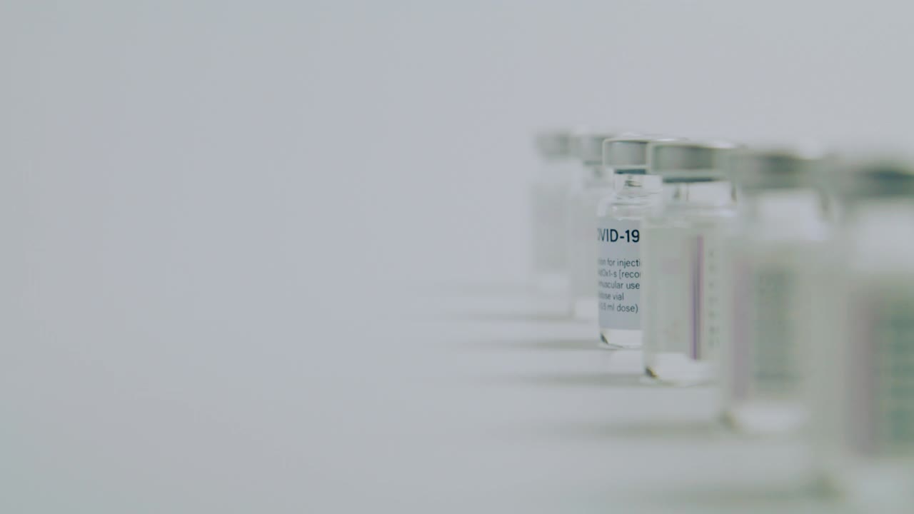 科学家或医生的手将COVID-19疫苗瓶从队列中取出视频下载