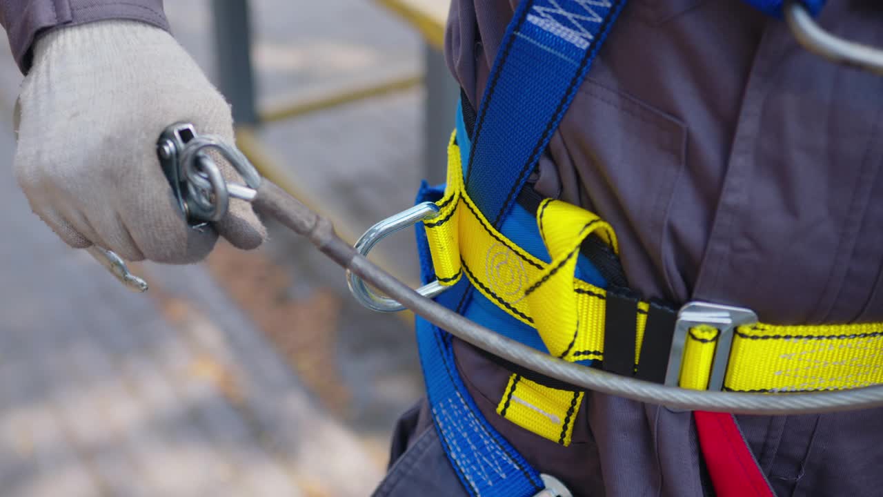 工业攀登者穿上高空作业设备。在攀登者的皮带钩环上。视频下载