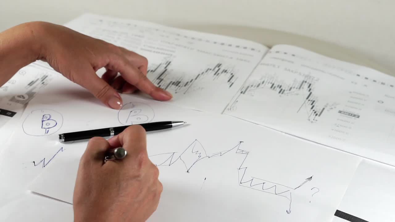 比特币股票图表分析:经纪人、交易员或投资者正在分析加密货币股票图表视频素材