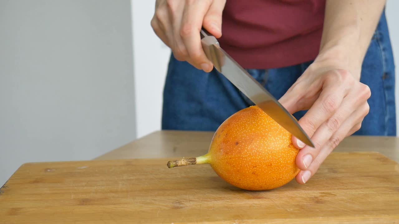 新鲜的有机成熟的格拉纳迪拉或黄色百香果切成两半放在木板上。异域水果，健康饮食理念视频素材