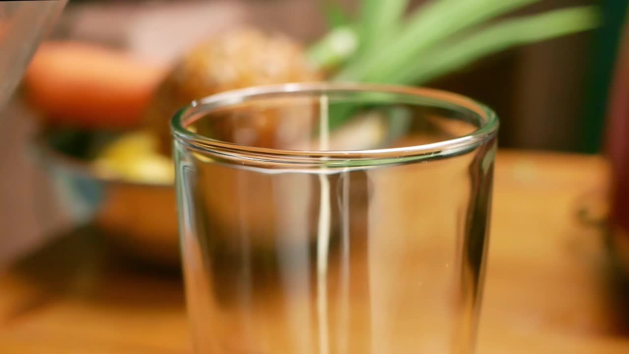 特写手把绿叶沙拉甘蓝冰沙倒进玻璃杯。健康饮食的概念。排毒和健康的生活方式。视频素材