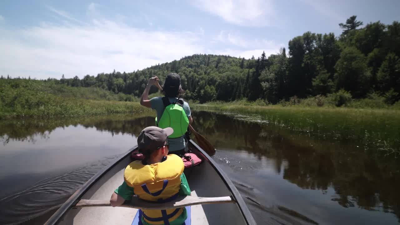 在加拿大魁北克省的帕克国立毛里西(Parc National de la Mauricie)，一家人在瓦皮扎冈克(Wapizagonke)湖中划独木舟视频下载
