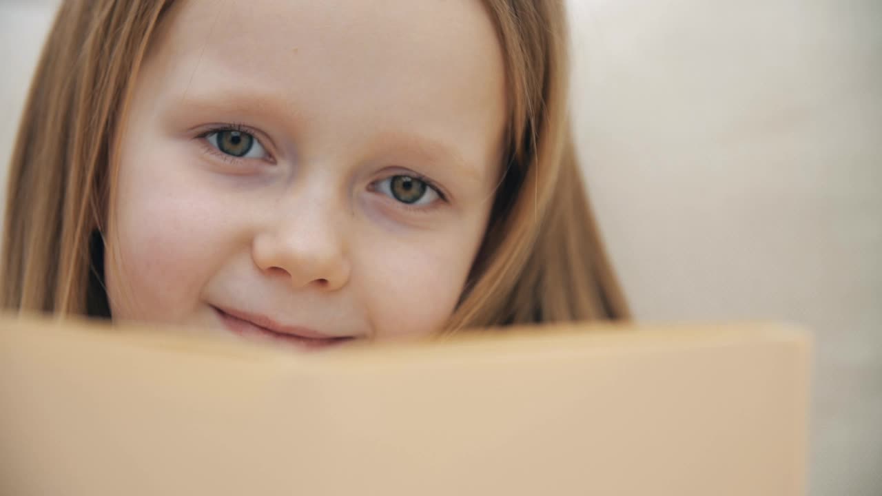小女孩拿着一本书的4k慢动作视频。视频素材